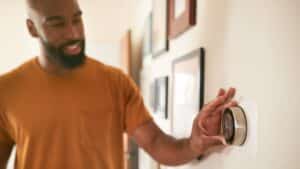 man adjusting home thermostat