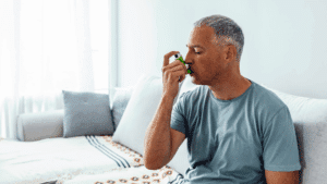 man using inhaler at home