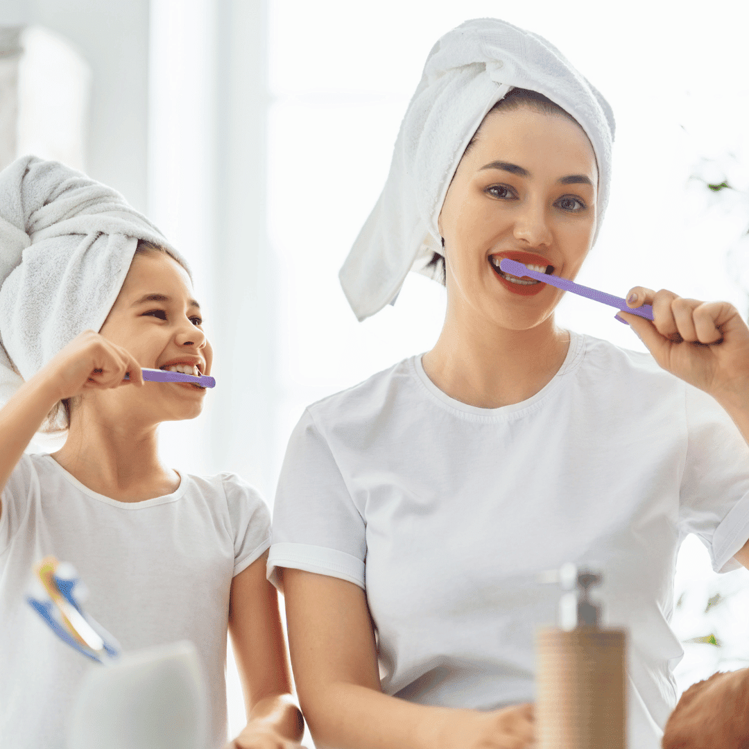 family brushing teeth at sink