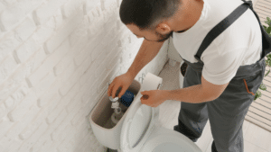 person repairing a toilet