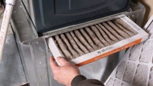 person replacing their furnace filter